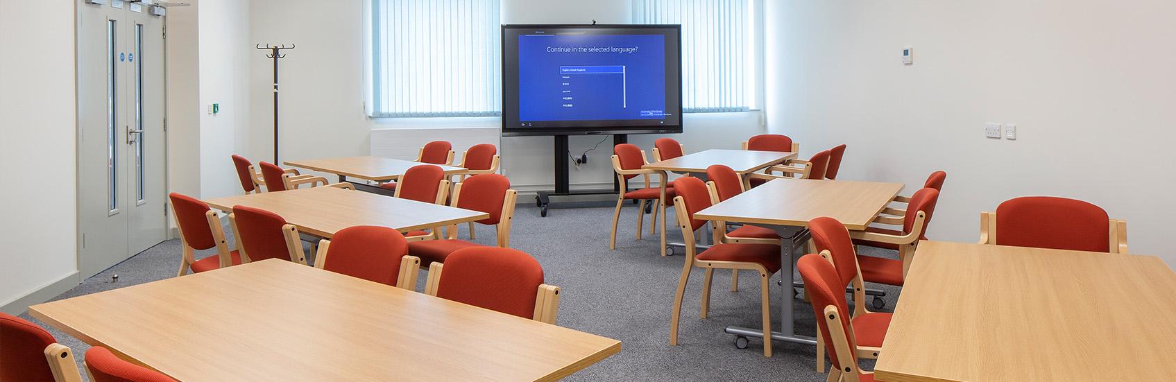 Breakout room with a number of tables and chairs